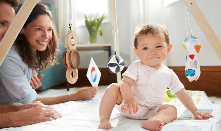 Baby sitting under The Play Gym by Lovevery