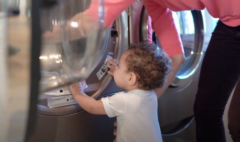 Baby looking into a washing machine