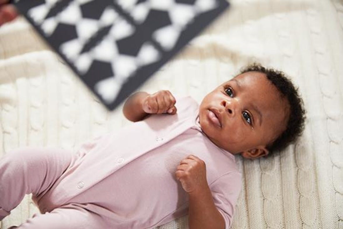 Baby laying on the ground looking up at the Black and White Contrast Cards by Lovevery