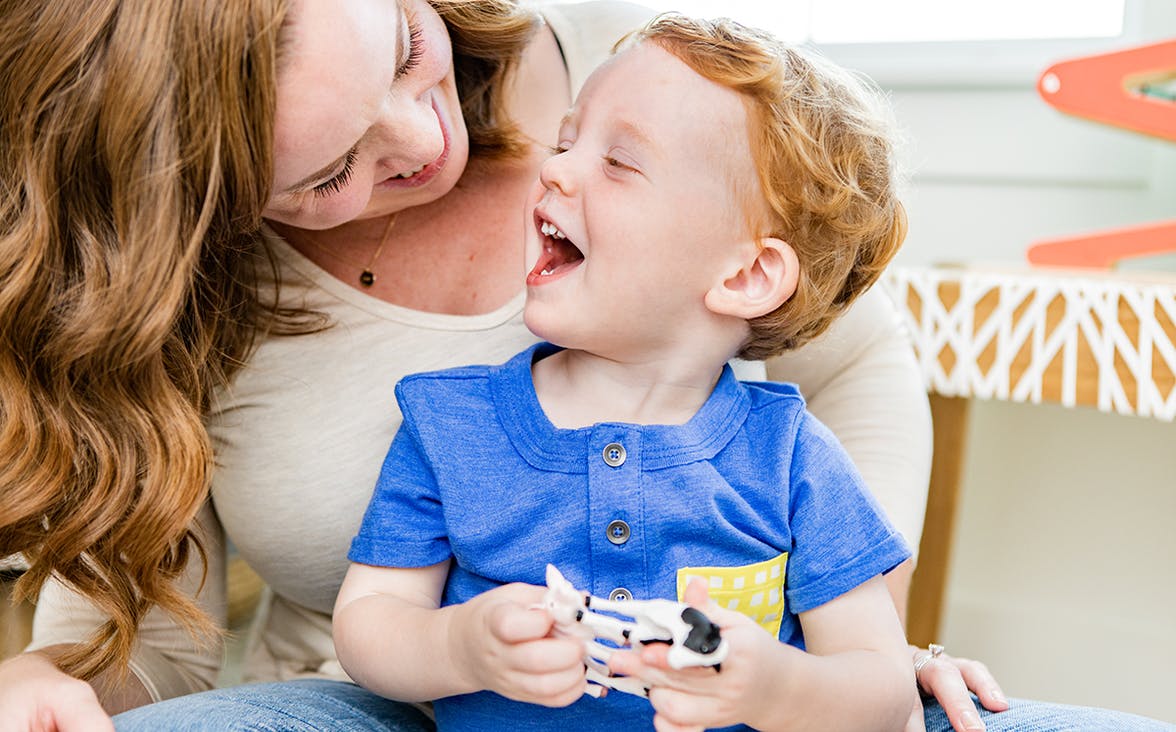 Child and woman looking at each other smiling 