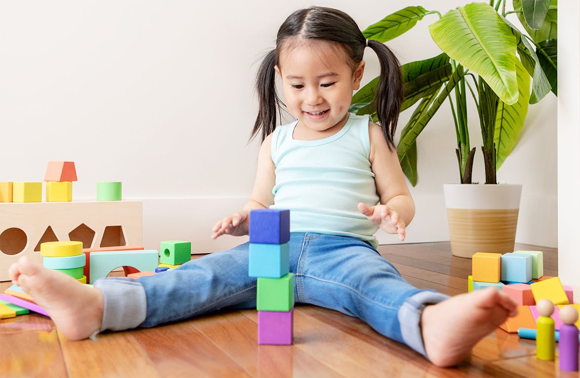Young child stacking blocks from The Block Set by Lovevery