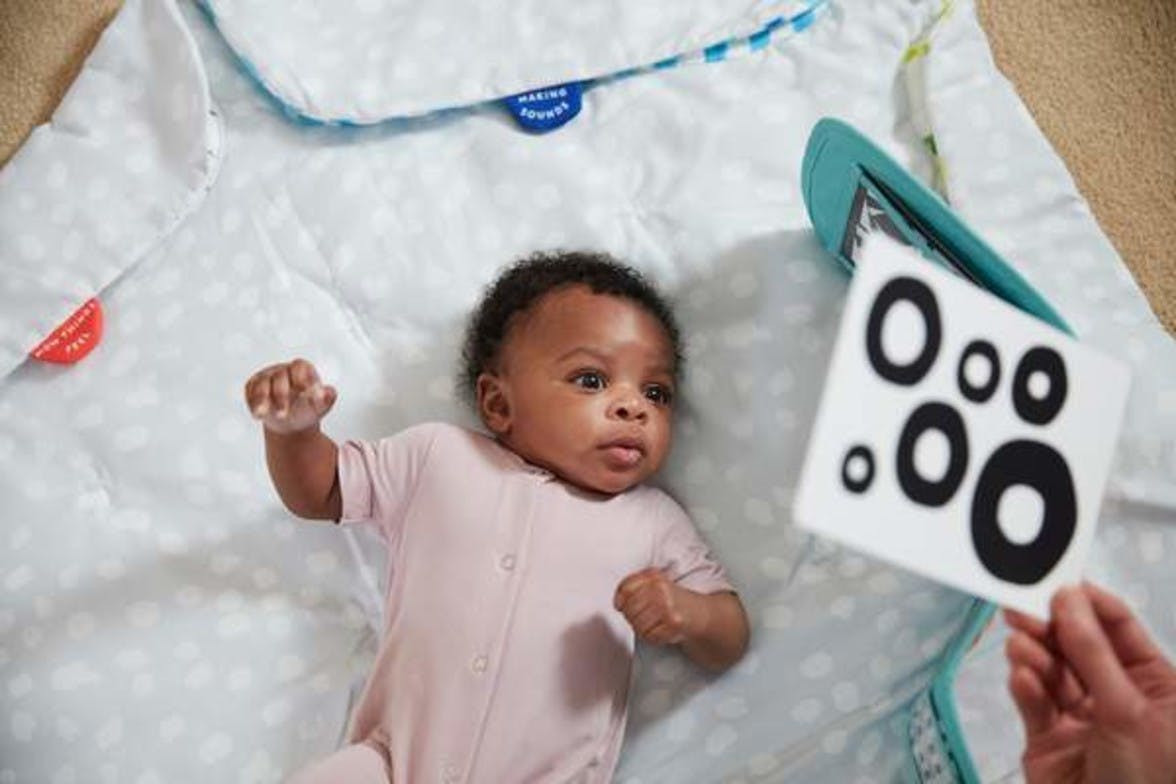 Baby laying under The Play Gym looking at Black and White Contrast Cards by Lovevery