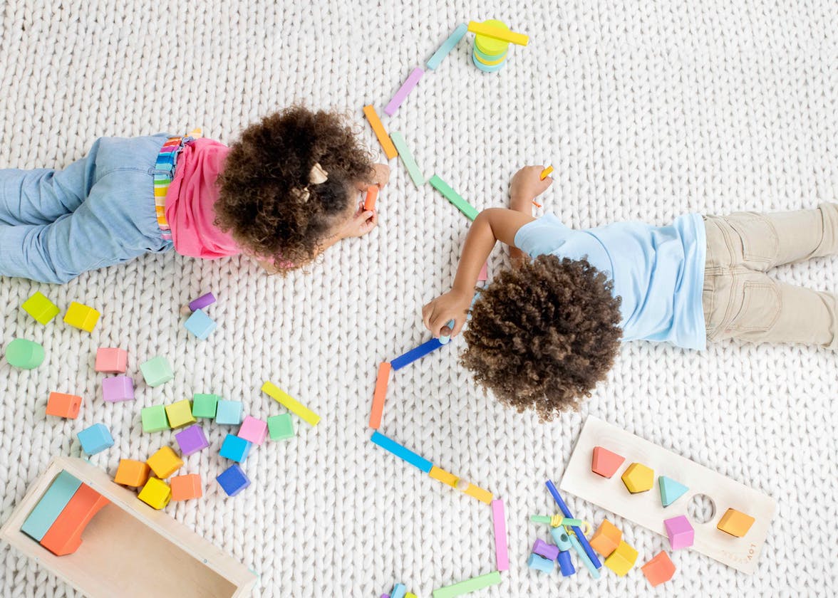 Two young children playing with the Block Set by Lovevery