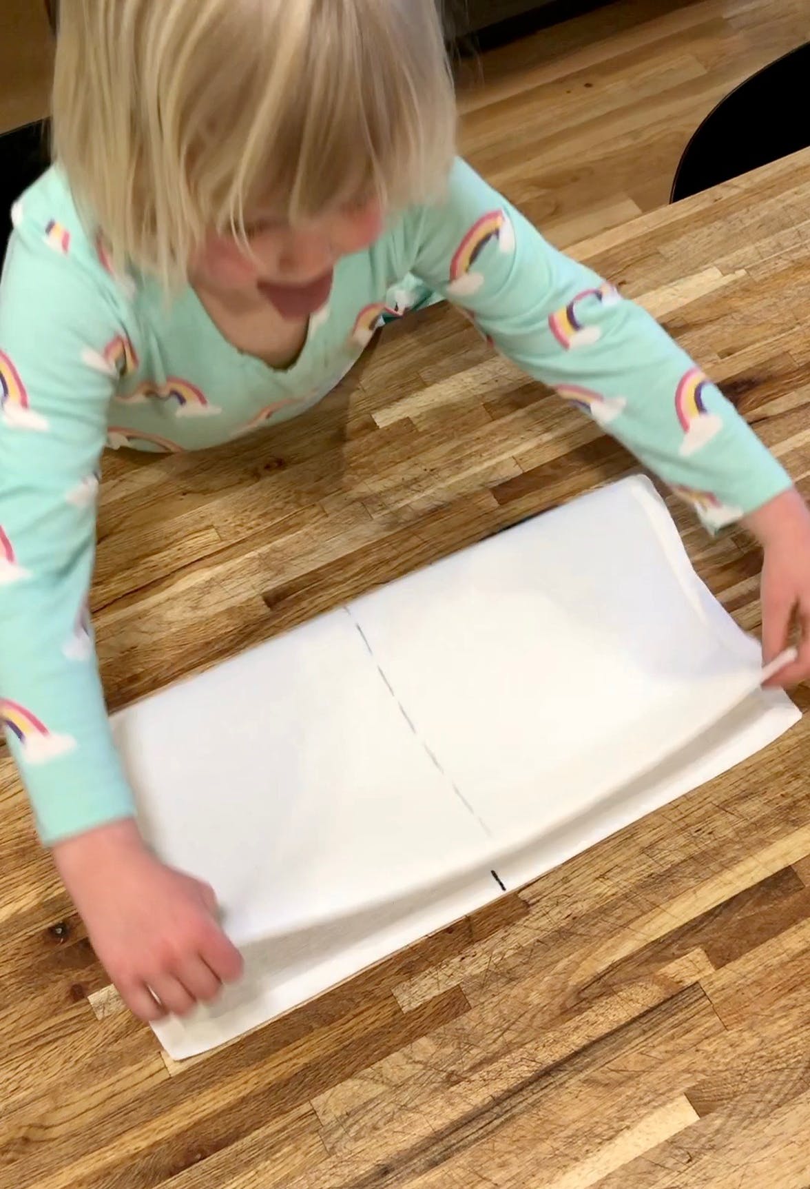 Young child folding a napkin in half