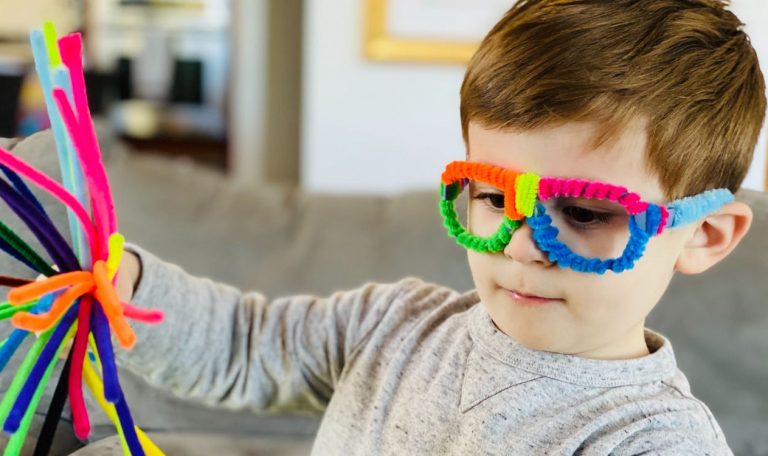 Young child wearing glasses decorated with pipe cleaners