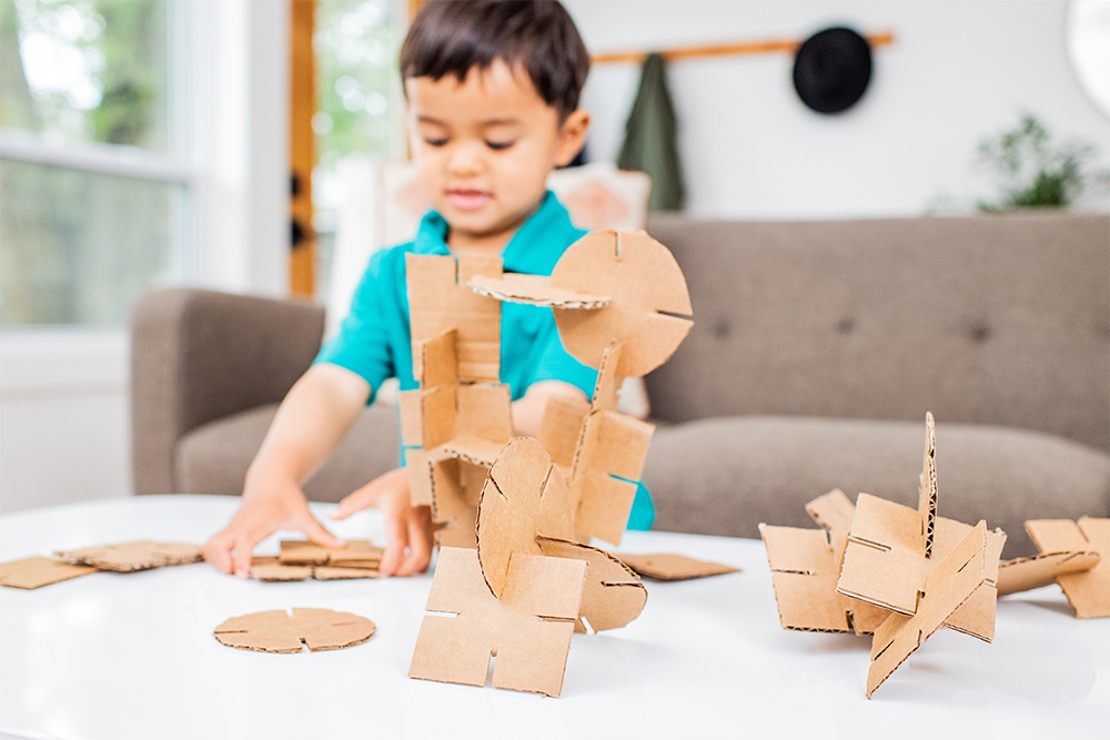 Young child putting together pieces of cardboard