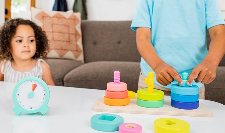 Two children taking turns playing with the Twist and Pivot Pattern Puzzle by Lovevery