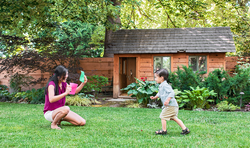 Toddler running to a woman outside while she holds a green card