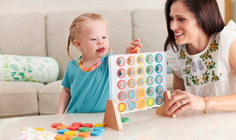 Young child playing with the Drop and Match Dot Catcher by Lovevery