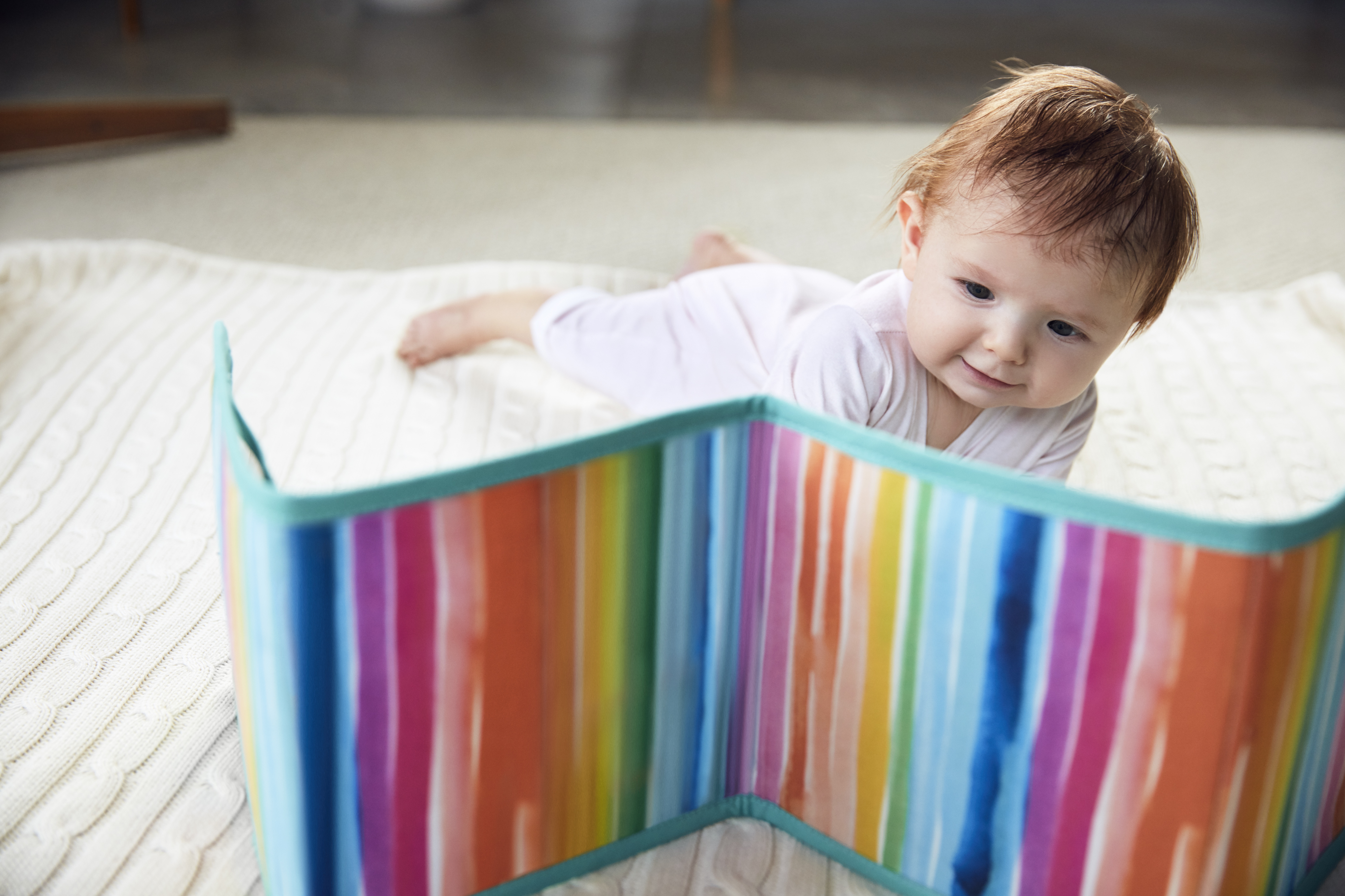 Baby doing tummy time while looking at the Standing Card Holder by Lovevery