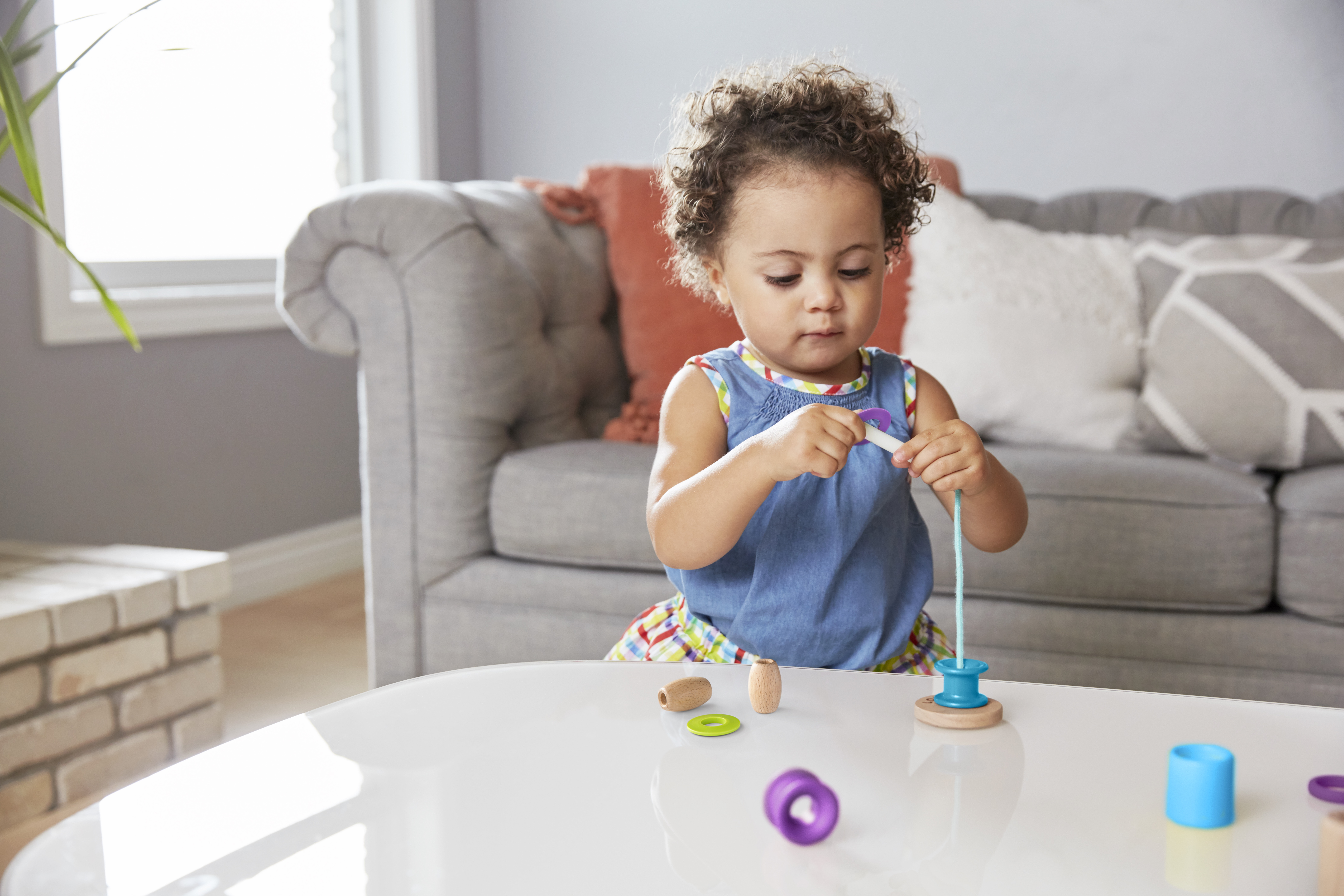 Young child playing with the Threadable Bead Set by Lovevery