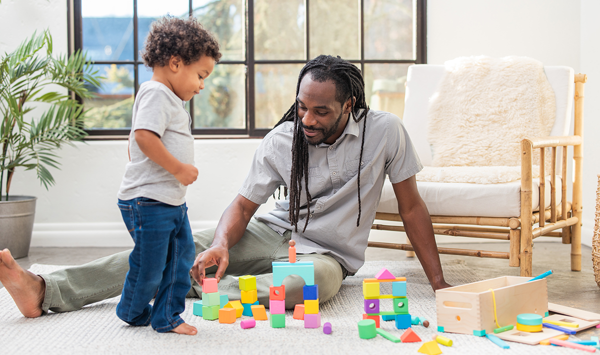Man and toddler playing with The Block Set by Lovevery