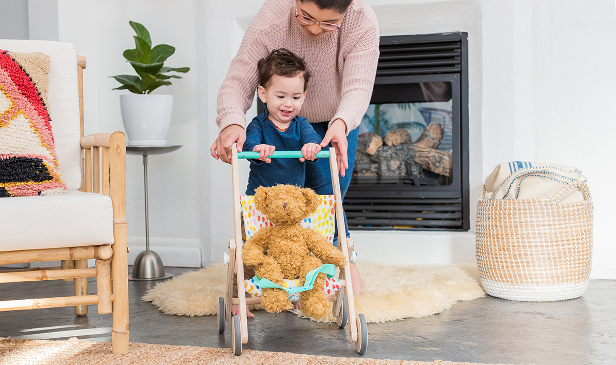 Toddler pushing the Buddy Stroller by Lovevery