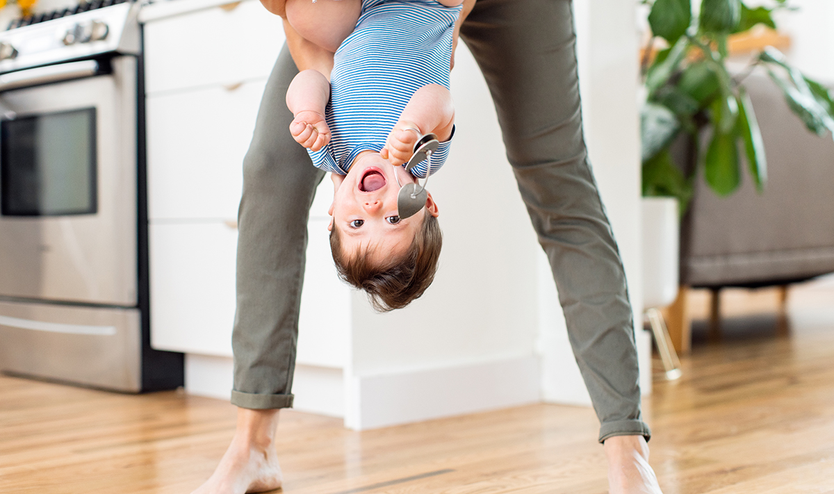 Woman holding a toddler upside down while they're holding the Jingle Keys