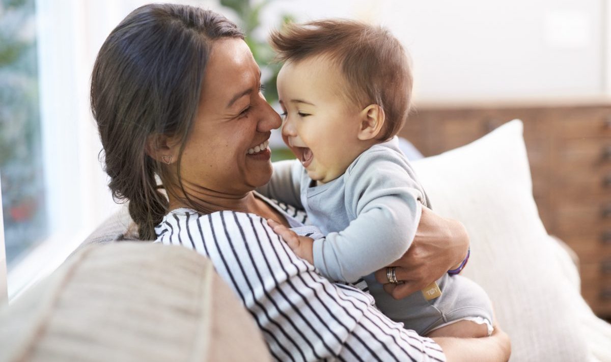 Woman holding a baby as they smile to each other