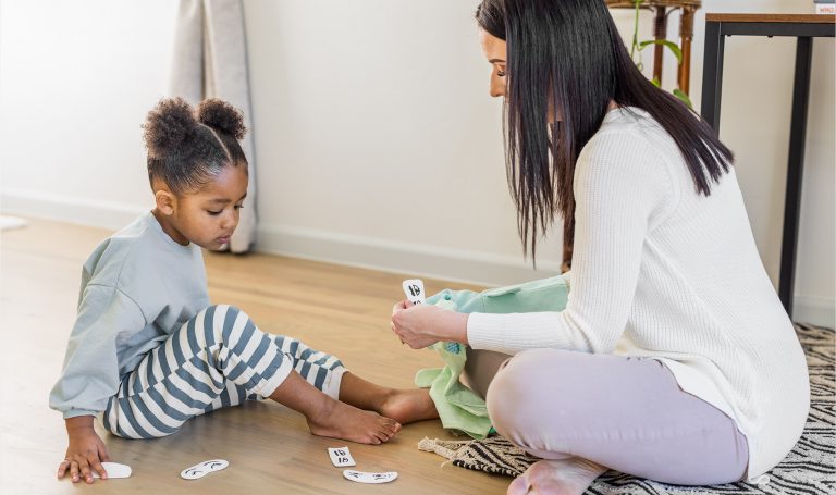 Mother helps her child name emotions using cards.